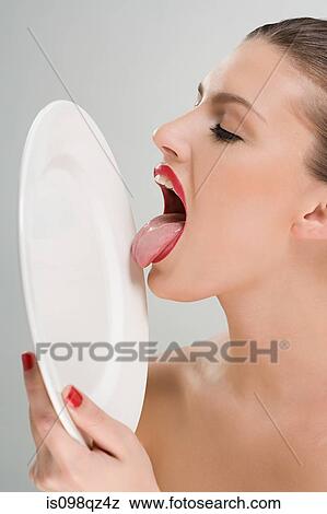 Stock Photo - Woman licking a plate. Fotosearch