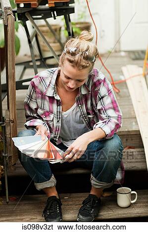 Stock Photograph - Woman looking at color swatch. Fotosearch
