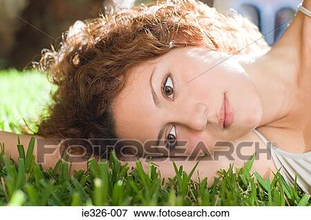 Woman lying on grass View Large Photo Image Stock Photo - Woman lying on grass. Fotosearch