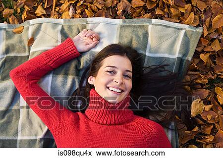 Stock Photo - Woman lying on leaves. Fotosearch