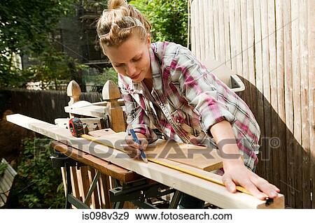 Woman measuring plank of wood View Large Photo Image Stock Photo - Woman measuring plank of wood. Fotosearch