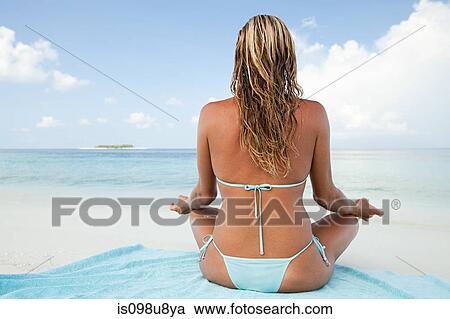 Stock Image - Woman meditating, Maadaugalla Island, North Huvadhu Atoll, Maldives. Fotosearch