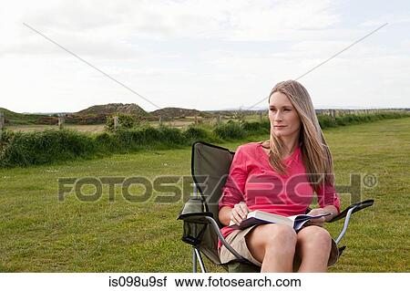 Woman on a camping chair in field View Large Photo Image Stock Image - Woman on a camping chair in field. Fotosearch