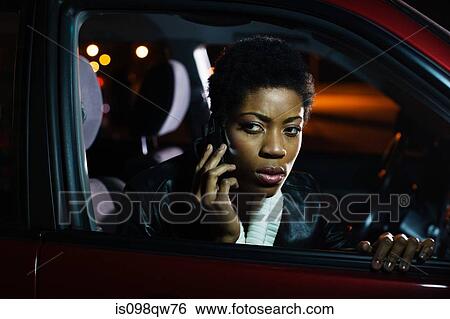 Stock Photograph - Woman on cellphone in car. Fotosearch