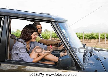 Stock Photo - Woman painting nails in suv. Fotosearch