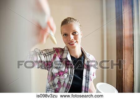 Stock Photograph - Woman painting wall. Fotosearch