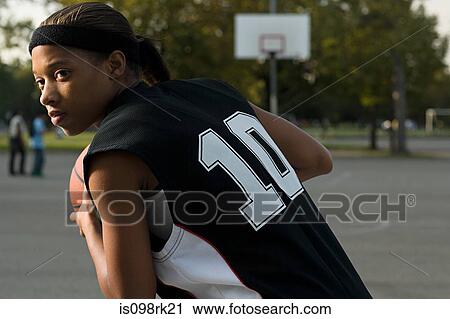 Stock Image - Woman playing basketball. Fotosearch