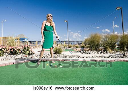 Woman playing miniature golf View Large Photo Image Stock Photograph - Woman playing miniature golf. Fotosearch