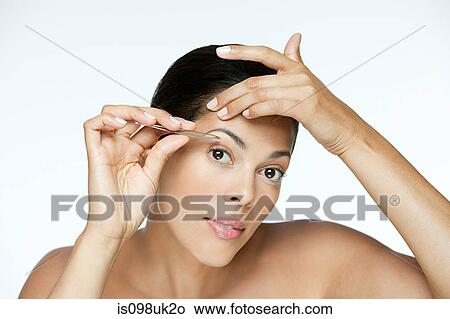 Woman plucking her eyebrows View Large Photo Image Picture - Woman plucking her eyebrows. Fotosearch