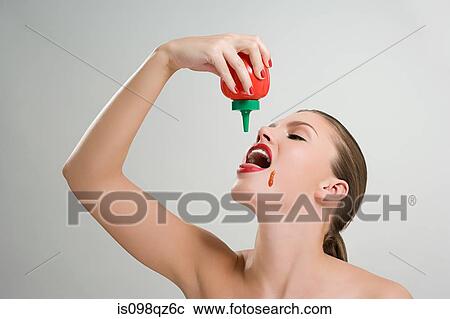 Woman pouring tomato ketchup into her mouth View Large Photo Image Stock Image - Woman pouring tomato ketchup into her mouth. Fotosearch