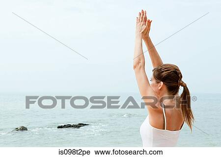 Woman practicing yoga by the ocean View Large Photo Image Stock Image - Woman practicing yoga by the ocean. Fotosearch