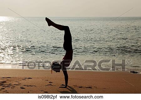 Woman practicing yoga on a beach at sunset View Large Photo Image Stock Image - Woman practicing yoga on a beach at sunset. Fotosearch