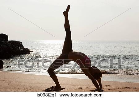Woman practicing yoga on a beach at sunset View Large Photo Image Stock Image - Woman practicing yoga on a beach at sunset. Fotosearch