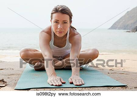 Woman practicing yoga on a beach View Large Photo Image Stock Photo - Woman practicing yoga on a beach. Fotosearch