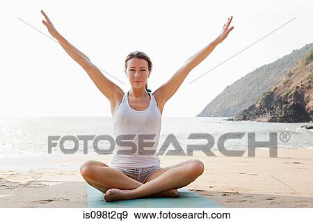 Woman practicing yoga on a beach View Large Photo Image Stock Photo - Woman practicing yoga on a beach. Fotosearch