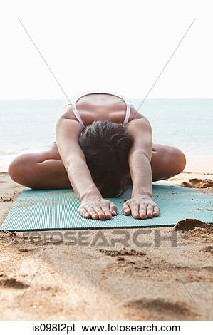 Woman practicing yoga on a beach View Large Photo Image Stock Photograph - Woman practicing yoga on a beach. Fotosearch