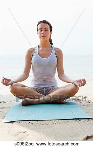 Woman practicing yoga on a beach View Large Photo Image Stock Photography - Woman practicing yoga on a beach. Fotosearch