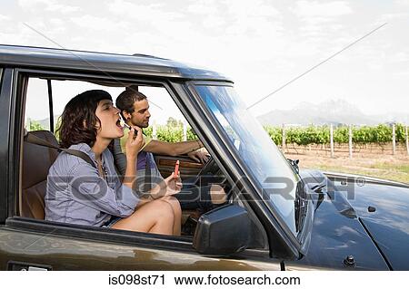 Woman putting on lipstick in vehicle View Large Photo Image Stock Image - Woman putting on lipstick in vehicle. Fotosearch