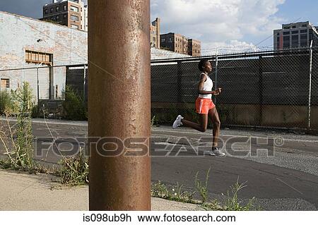 Stock Image - Woman running in brooklyn. Fotosearch