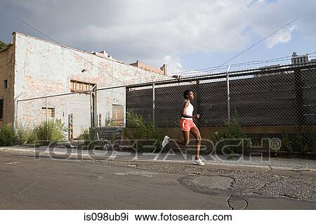Stock Image - Woman running in brooklyn. Fotosearch