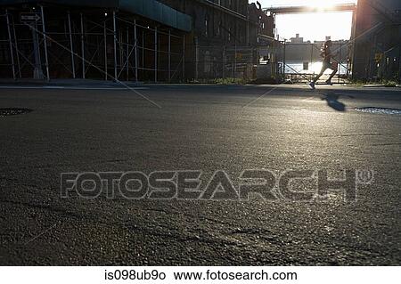 Picture - Woman running on road. Fotosearch