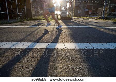 Stock Image - Woman running on road. Fotosearch
