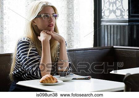Woman sitting in coffee shop View Large Photo Image Stock Photo - Woman sitting in coffee shop. Fotosearch