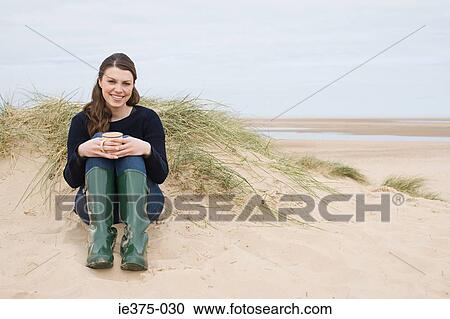 Woman sitting on a sandy beach View Large Photo Image Stock Image - Woman sitting on a sandy beach. Fotosearch