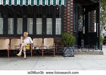 Woman sitting outside coffee shop View Large Photo Image Stock Image - Woman sitting outside coffee shop. Fotosearch
