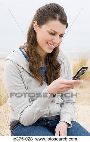 Woman text messaging on beach View Large Photo Image Stock Photo - Woman text messaging on beach. Fotosearch