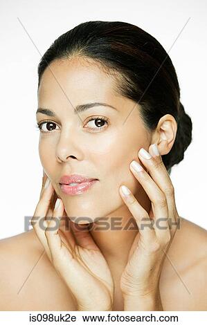 Stock Image - Woman touching her face. Fotosearch