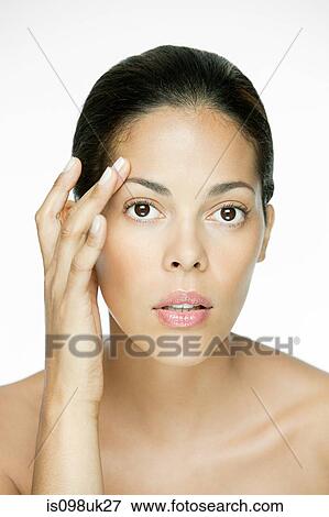 Woman touching her face View Large Photo Image Stock Photo - Woman touching her face. Fotosearch