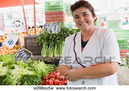 Stock Photo - Woman trader at vegetable stall. Fotosearch