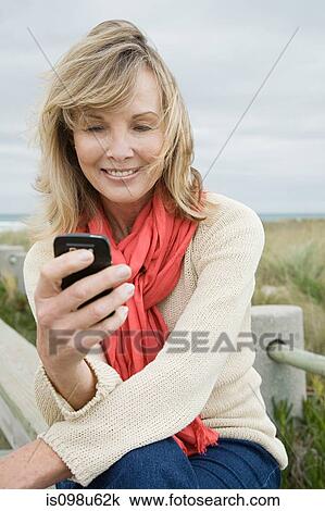 Stock Image - Woman using cellphone. Fotosearch