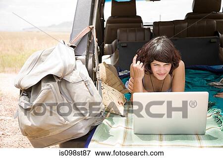 Stock Photo - Woman using laptop in vehicle. Fotosearch