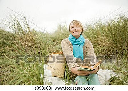 Woman with a book on a dune View Large Photo Image Stock Photography - Woman with a book on a dune. Fotosearch