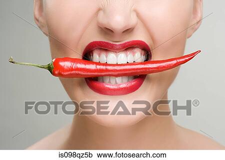 Woman with a red chili pepper between her teeth View Large Photo Image Stock Image - Woman with a red chili pepper between her teeth. Fotosearch