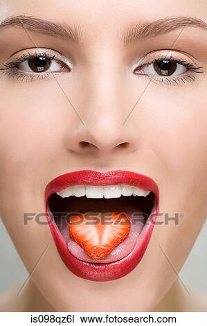 Woman with a slice of strawberry on her tongue View Large Photo Image Stock Image - Woman with a slice of strawberry on her tongue. Fotosearch