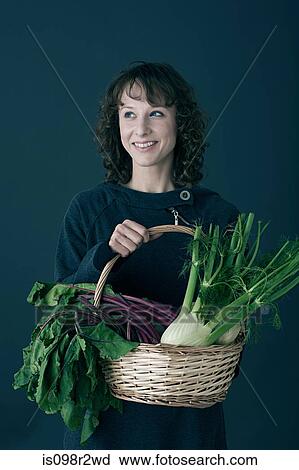 Stock Image - Woman with basket of vegetables. Fotosearch