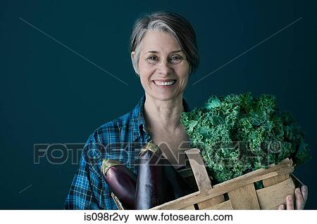 Stock Photo - Woman with basket of vegetables. Fotosearch