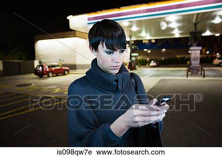 Woman with cellphone at gas station View Large Photo Image Stock Image - Woman with cellphone at gas station. Fotosearch