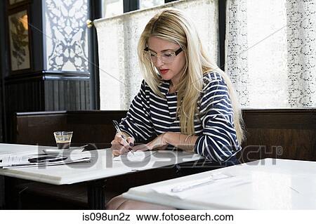 Woman writing in coffee shop View Large Photo Image Stock Photo - Woman writing in coffee shop. Fotosearch