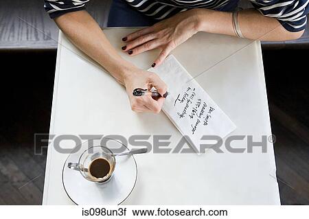 Stock Image - Woman writing note on napkin. Fotosearch