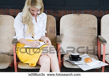 Woman writing outside coffee shop View Large Photo Image Stock Photo - Woman writing outside coffee shop. Fotosearch