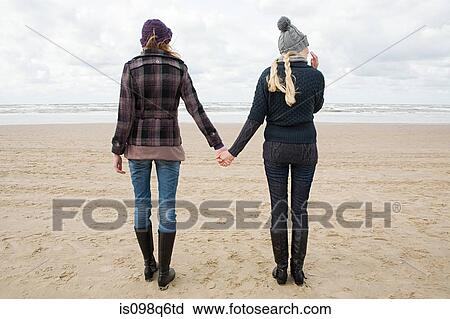 Women holding hands at the beach View Large Photo Image Stock Image - Women holding hands at the beach. Fotosearch