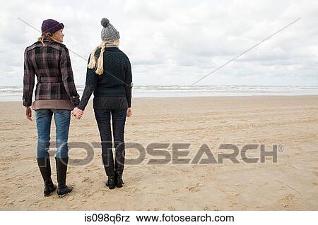 Women holding hands by the sea View Large Photo Image Stock Photo - Women holding hands by the sea. Fotosearch