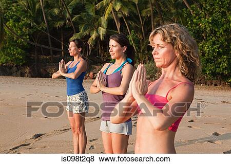 Women practicing yoga on a beach View Large Photo Image Stock Photo - Women practicing yoga on a beach. Fotosearch