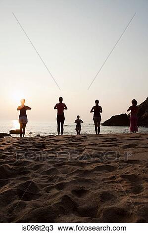 Women practicing yoga on beach at sunset View Large Photo Image Stock Image - Women practicing yoga on beach at sunset. Fotosearch