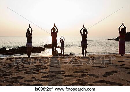 Women practicing yoga on beach at sunset View Large Photo Image Stock Image - Women practicing yoga on beach at sunset. Fotosearch