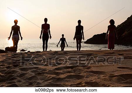 Women practicing yoga on beach at sunset View Large Photo Image Stock Photograph - Women practicing yoga on beach at sunset. Fotosearch